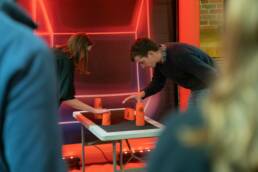 A man and a woman are in the qube playing stack,
