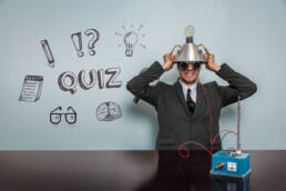 Man sitting at a desk with a make shift tin hat, ready to take part in an Ultimate quiz
