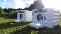 Two giant inflatable washing machines in a field, for team mates to run into during our teambuilding event 'It's a knockout!'
